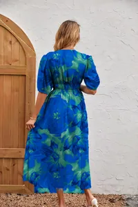 Back view of a blue and green floral print maxi dress with puff sleeves and elastic waist