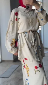 Detailed macro view of the elegant floral print on cream long sleeve shirt and skirt set