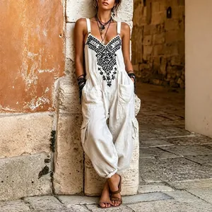 Close-up detail of white bohemian summer jumpsuit with black ethnic chest embroidery