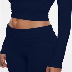 Close-up detail of navy blue long sleeve crop top and low waist yoga leggings set for women