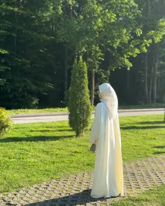 Elegant white cotton linen long abaya robe set in a natural outdoor park setting