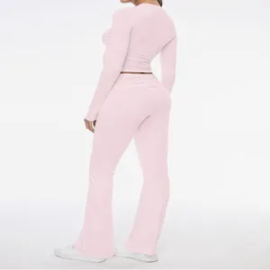 Back view of a slim fit pink two-piece set featuring a long sleeve top and flared pants.