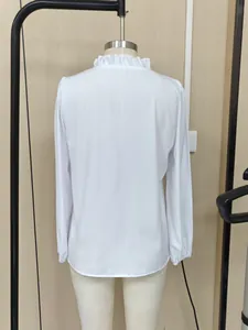 Vista trasera de esta blusa blanca de manga larga con un elegante detalle de cuello volante