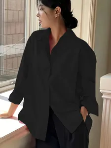 Detailansicht eines minimalistischen schwarzen Oversized-Baumwollhemds für Damen.