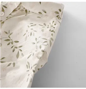 Close-up of the vintage leaf print and collar detail on a cream linen shirt for women