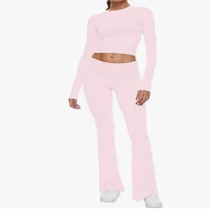 Front view of pink slim fit two-piece set with long sleeve crop top and flared pants