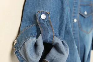 Gros plan détaillé sur la manche d'une chemise en jean bleue avec patte de boutonnage