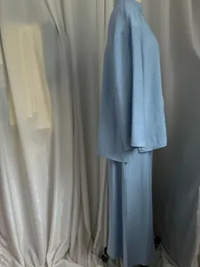 Side view detail of light blue asymmetric long shirt and skirt set in linen-like fabric