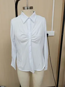 Detailed view of women's white slim-fit office shirt with elegant pleated front on mannequin