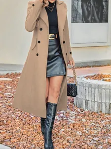 Dettaglio di cappotto di lana cammello a doppio petto con gonna di pelle nera e stivali