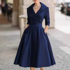 Elegant navy blue satin midi dress featuring a flared pleated skirt and waist-cinching design