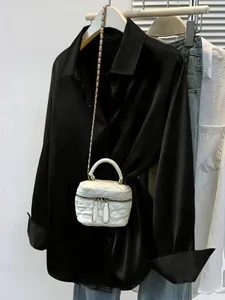Detailed view of women's black satin button-up shirt featuring a silky glossy finish