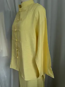 Detail view of a yellow Chinese style asymmetrical linen shirt on a mannequin