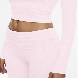 Close-up detail of the light pink long sleeve crop top and matching high-waisted flared pants.
