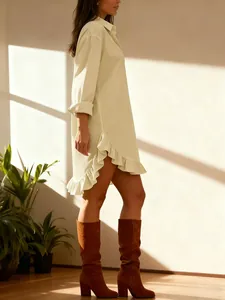 Side view detail of a chic beige long-sleeved shirt dress with ruffled hemline