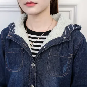 Close-up detail of winter hooded denim jacket showing soft white fleece lining texture