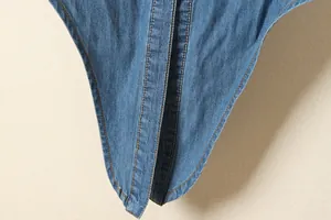 Gros plan montrant les coutures et la texture d'un tissu de chemise en jean bleu