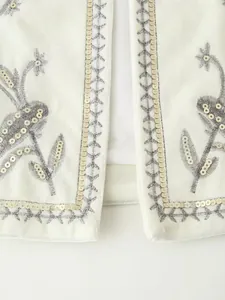 Dettaglio dell'elegante gilet in velluto bianco con paillettes e ricami