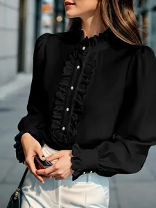 Detail view of elegant black long-sleeve blouse with ruffle trim and pearl buttons