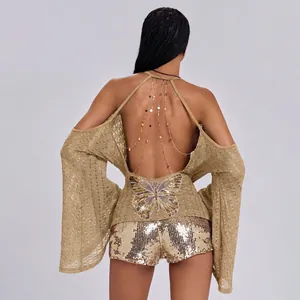 Achterkant detail van sexy goudkleurige backless top met vlindermotief en kettingen
