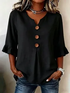Close-up of black cotton linen blouse with V-neck, large wooden buttons and ruffle sleeves.