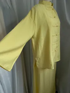 Detailed side view of yellow linen-style Chinese blouse with traditional frog buttons