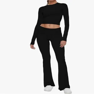 Full body view of women's black two-piece set with long sleeve crop top and flared trousers