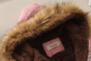 Λεπτομέρεια ροζ χειμωνιάτικου μπουφάν με κουκούλα από συνθετική γούνα και ζεστή επένδυση fleece