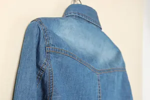 Gros plan détaillé d'une veste de chemise en jean bleu avec surpiqûres orange