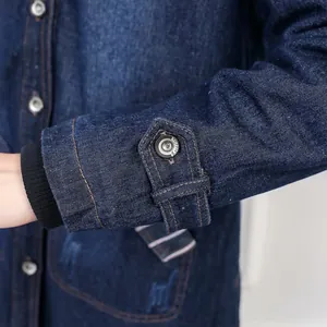 Detail view of denim jacket sleeve with decorative button and ribbed windproof cuff