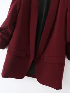 Primer plano de la elegante solapa de un blazer burdeos para mujer con bolsillos