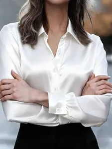 Macro view showing the glossy satin texture and button details of this white blouse