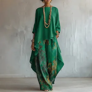 Detailed view of women's emerald green two-piece set with asymmetrical top and printed pants