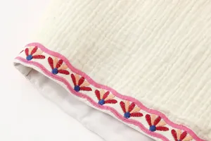 Primer plano detallado del bordado de estilo étnico en el dobladillo del chaleco.