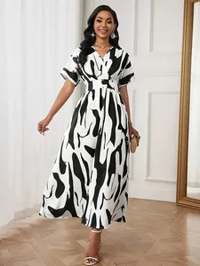 Elegant black and white abstract print maxi dress with V-neck and cinched waist on model.