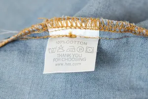 Gros plan sur l'étiquette de lavage 100 % coton d'une chemise en jean bleue pour femme