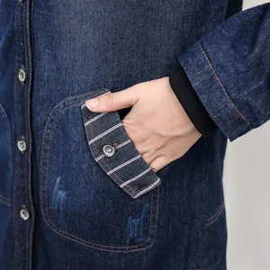 Close-up detail of pocket and striped trim on long denim winter jacket for women