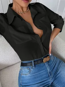 Detalle de camisa negra de manga larga con bolsillos y cuello, diseño elegante