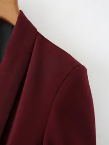 Primer plano de un blazer color burdeos que muestra la textura de la tela y el hombro.