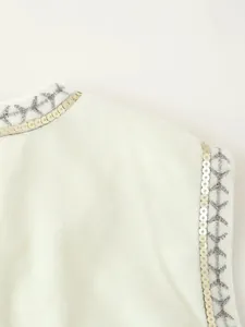 Dettaglio ravvicinato di paillettes e ricami su questo gilet in velluto bianco