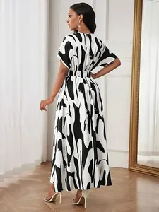 Back view of a chic black and white abstract print maxi dress with cinched waist