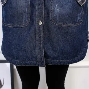 Detail shot of mid-length denim jacket showing front pockets and hemline texture