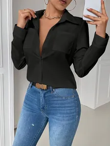 Detalle de una elegante camisa negra de manga larga con solapa y bolsillos.