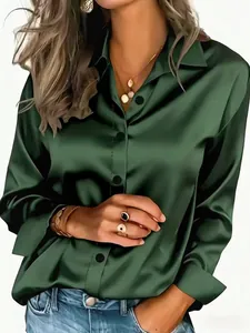 Detailed shot of an elegant glossy emerald green satin long-sleeve women's shirt