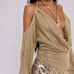 Detail van sexy champagne gebreide top met diepe V-hals en losse vleermuismouwen