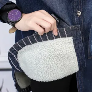 Close-up detail of thick white sherpa fleece lining inside a blue denim winter jacket