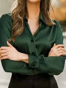 Detailed view of women's dark green satin long-sleeve shirt with silky texture
