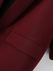 Detalle de una americana granate de mujer que muestra el bolsillo y la textura.