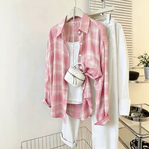 Detailed view of a pink and white plaid chiffon blouse styled with a white mini bag