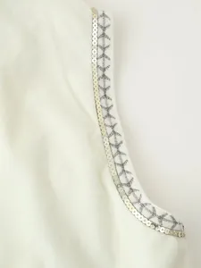 Primo piano dettagliato di paillettes d'argento e ricami di stelle su gilet bianco